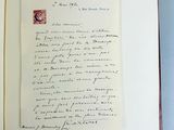 an open book with a handwritten letter on it sitting on a blue surface