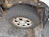 a white truck with a flat tire on the side of the road