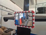 a reflection of a train in a mirror on the side of the train