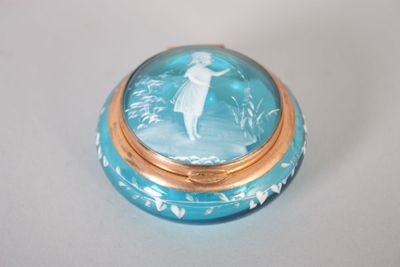 une boîte bleue et dorée sur laquelle figure l'image d'une femme
