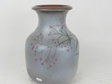 a blue vase with pink flowers on it on a white surface