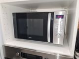 a microwave that is built into a shelf in the kitchen