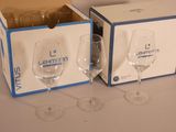 three wine glasses sitting next to a box on a table