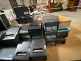 a lot of old computers on a table in a warehouse