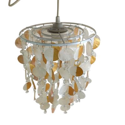 une photo d'un lustre blanc et doré suspendu au plafond