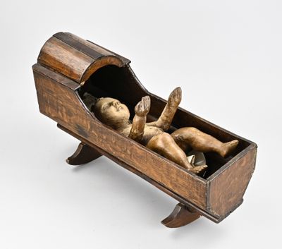 sculpture of a baby in a wooden cradle on a white background