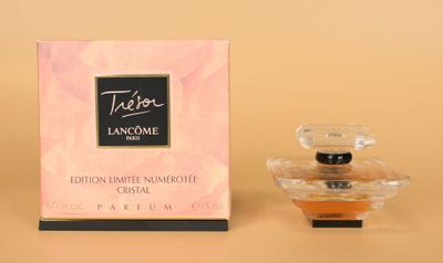 gros plan d'un flacon de parfum à côté d'une boîte