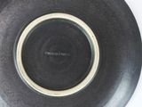 a black plate with a brown rim on a white table
