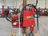 une machine rouge posée sur une palette dans un entrepôt