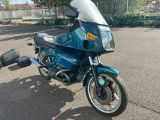 a blue motorcycle that is parked in a parking lot