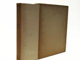 an old book sitting on top of a white table next to a white wall