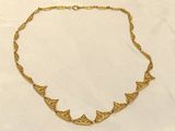 a gold necklace on a white background