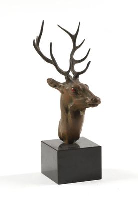 sculpture représentant une tête de cerf avec des bois, posée sur un socle noir