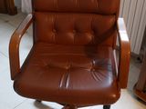 une chaise de bureau en cuir marron placée dans un coin de la pièce