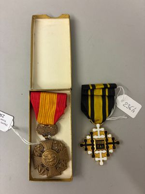 deux médailles et une médaille se trouvent dans une boîte posée sur une table