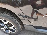 a man riding a skateboard on the street next to a car