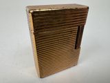 an image of a gold cigarette case sitting on top of a white table