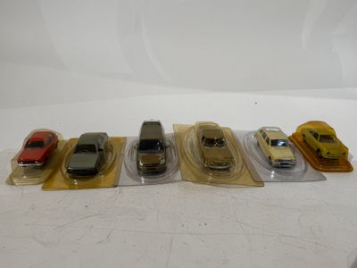 five toy cars lined up in a row on a table