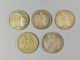 quatre types différents de pièces d'or sur une surface blanche
