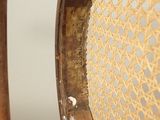 an old wooden chair with a hole in the back of it