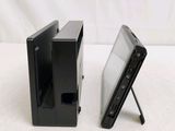two black video game consoles side by side on a white surface