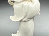 a white figurine of a woman with a basket on her head