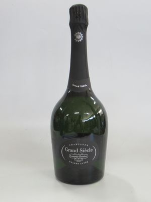 une bouteille de champagne posée sur une surface blanche