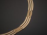 a gold necklace on a black surface