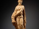 une statue représentant une femme tenant un panier de fleurs