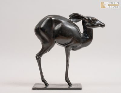 une statue en bronze représentant une antilope, posée sur un socle en marbre