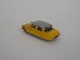 yellow toy car sitting on a white surface with a black roof
