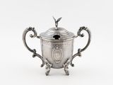 une théière ancienne en argent, à deux anses, surmontée d'un oiseau