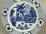 blue and white plate with a picture of a man and a woman on a bridge