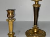 deux bougeoirs en or posés sur une table blanche