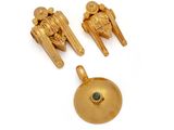 three pieces of gold jewelry on a white surface with a green stone
