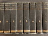 six vieux livres sont alignés en rangées sur une table