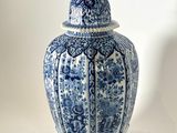 a blue and white vase with a lid on a table