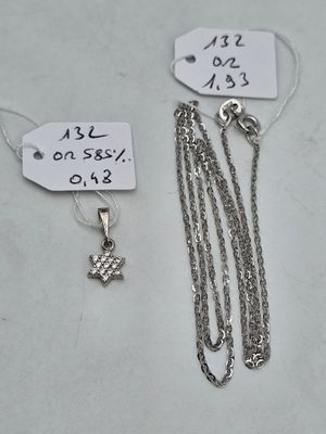 two silver necklaces and a silver chain with a star on it