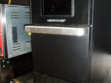 a black oven sitting on top of a metal table
