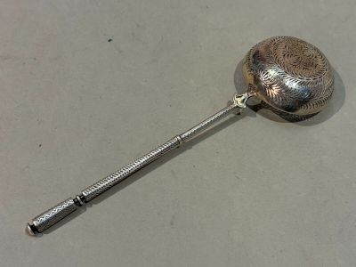 a silver spoon with a handle on a table