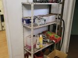 a shelving in the corner of a room with tools and supplies on it