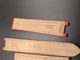 two leather watch straps with red stitching on them on a black surface