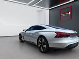 the rear end of a silver sports car parked in a garage