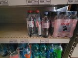 many bottles of water on the shelves in the store