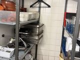 many pots and pans on the shelves in the kitchen