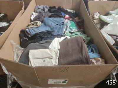 une boîte en carton pleine de vêtements posée sur le sol
