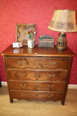 une commode en bois sur laquelle est posée une lampe