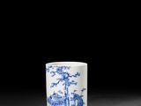 une tasse bleue et blanche ornée d'un motif représentant un paysage