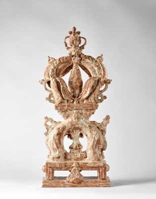 une horloge ancienne en bois surmontée d'une couronne