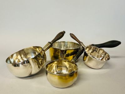four pieces of silverware sitting on top of a white surface